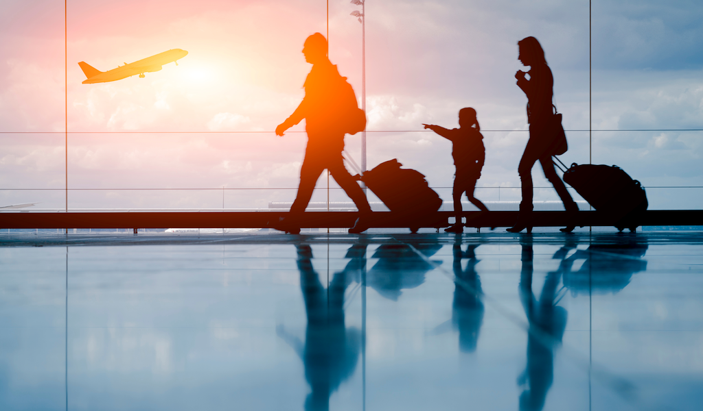 Young couple with child at the airport about to board an airplane.